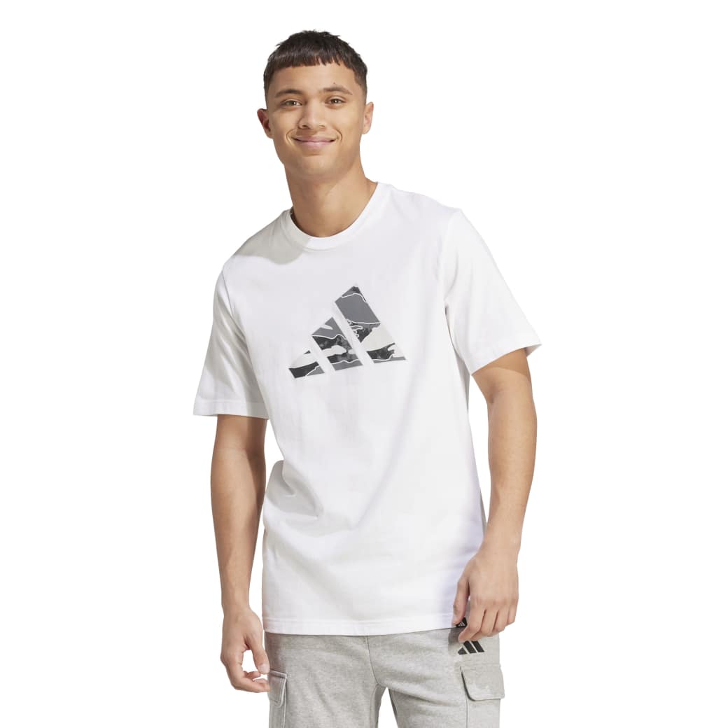 Modelo masculino sorridente vestindo camiseta Adidas branca com estampa camuflada frontal